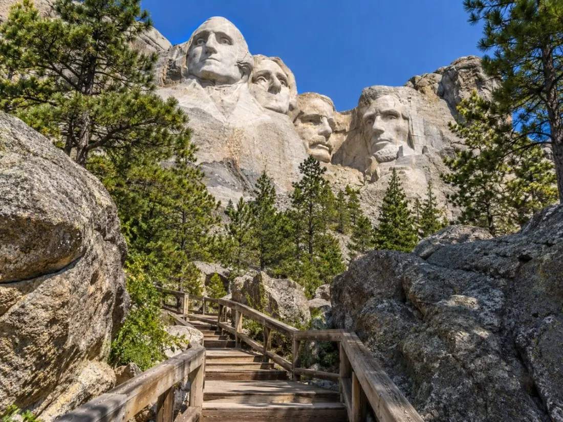 Wooden steps of the Presidential Trail among granite boulders below the carving